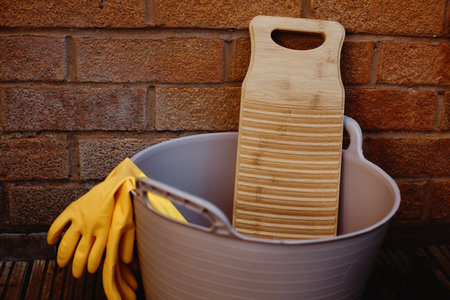 a bamboo laundry board in a rubber tub against a brick wallの写真素材