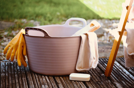 a rubber tub with a bamboo washboard and a pair of glovesの写真素材