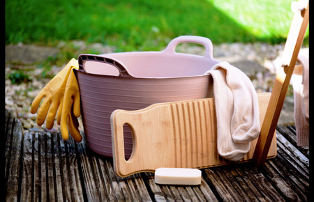 a rubber tub with a bamboo washboard and a pair of glovesの写真素材