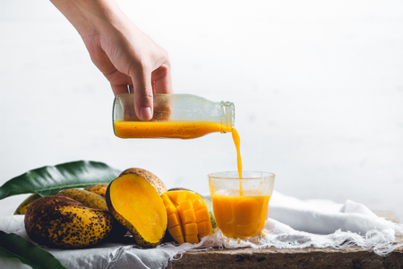 nature mango and mango juice On a wooden table and a white clothの写真素材