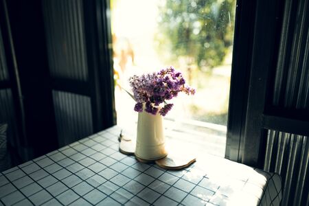 Flowers in a vase, on a table in a coffee shop in morningの写真素材