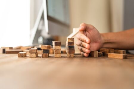 Stop falling wooden domino,Small wooden stacked On the desk at homeの写真素材