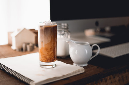 Iced coffee, put milk in a glass on the table to work at home