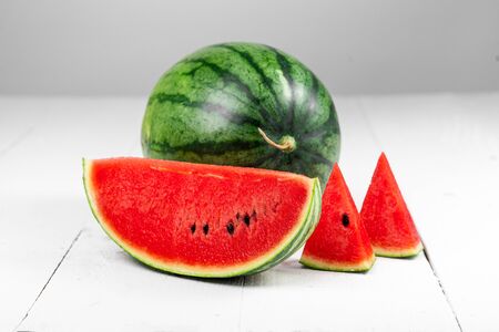 Watermelon-Watermelon Slices Against Wood White Backgroundの写真素材