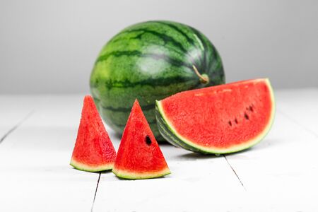 Watermelon-Watermelon Slices Against Wood White Backgroundの写真素材