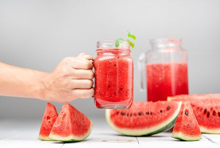 Watermelon juice in a glass-Watermelon Slices Against Wood White Backgroundの写真素材