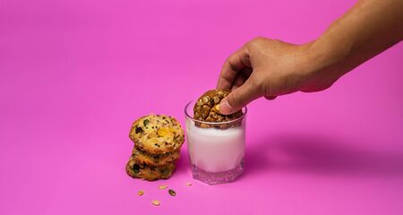 Cereal cookies and milk in a glass on a pink backgroundの写真素材