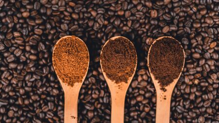Ground coffee in a spoon on the background, roasted coffee beansの写真素材
