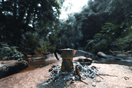 Brewing coffee in the forest with a moka pot in forestの写真素材