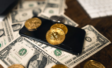 The crypto in the hand in front of the desk and on the computer graph.