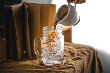 Iced coffee - Pouring milk to glass with coffeeの写真素材