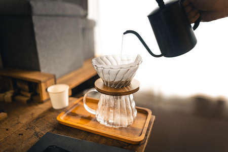 Drip coffee, barista pouring water on coffee ground with filter,brewing coffeeの写真素材