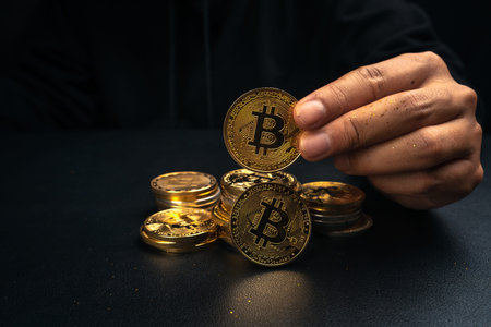 A golden bitcoin in the hand of a mysterious man,digital finance
