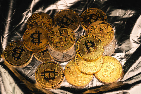 A golden bitcoin in the hand of a mysterious man,digital financeの写真素材