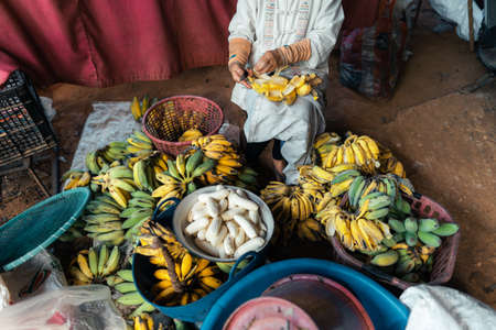 Banana in the hand of the seller for processingの写真素材