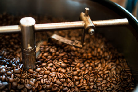 Freshly roasted aromatic coffee beans over a modern coffee roasting machine