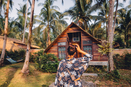 Woman with palm trees and house on islandの写真素材