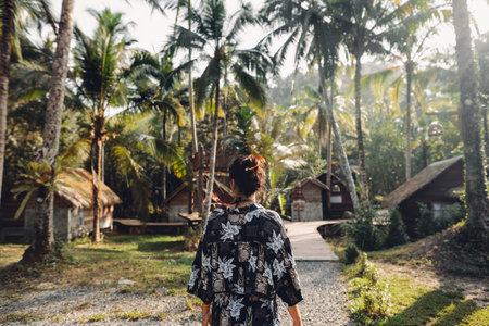Woman with palm trees and house on island