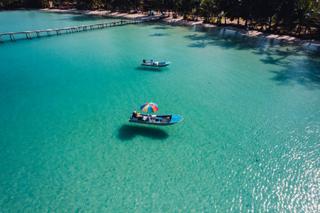 A boat floats on clear blue waters on an island,koh kood