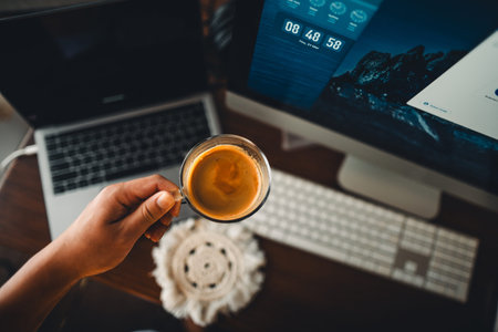 Espresso coffee in a cup in the morning at the computer desk