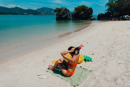 Woman sitting and sunbathing at the beach