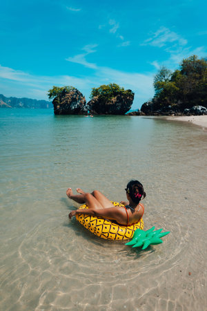Woman in a yellow inner tube at the beach