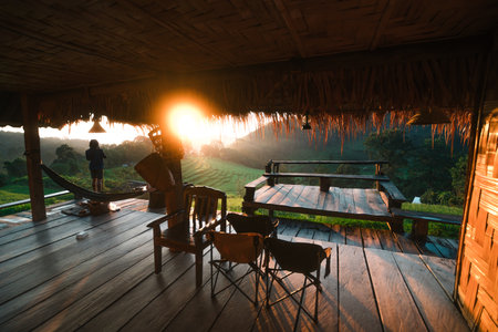 A man stands taking pictures on a rice terrace and in the morning light.の写真素材