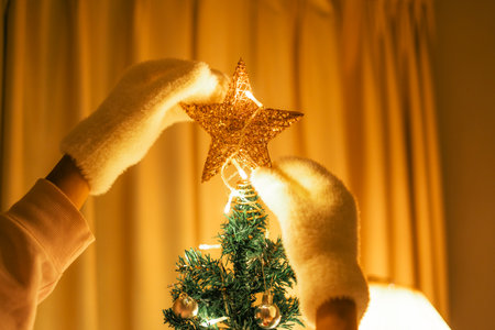 Hands decorating a Christmas tree starの写真素材