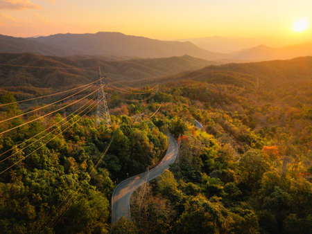 Aerial view of a road through a green and yellow deciduous forest in summer, on the way to Pai district.の写真素材