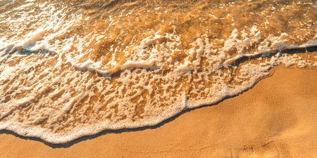 Sand on the beach and sea waves in the morning, orange tone.の写真素材