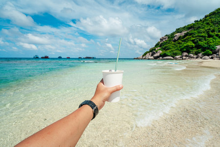 Paper coffee cups on the beach on an island, environmental protection and plastic reductionの写真素材