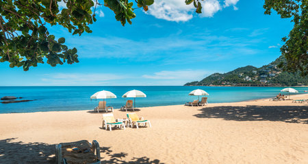 Tropical beach and sea with fresh summer sky on Koh Samui. Beach chairs and umbrellas. Seaside vacation. Summer getaway.の写真素材