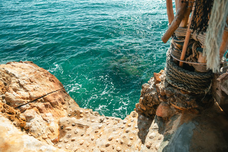 clarity of turquoise ocean water gently lapping against ancient, textured rock formationsの写真素材