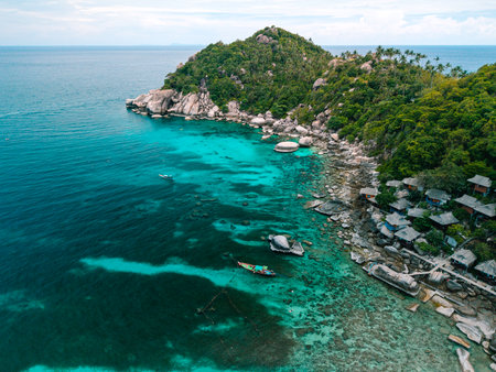 erial view captures the essence of a tropical paradise. A traditional colorful boat with a person standing on it floats gracefully on the crystal-clear turquoise waters.の写真素材