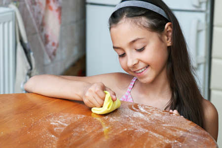 The smiling girl is wiping the dustの写真素材