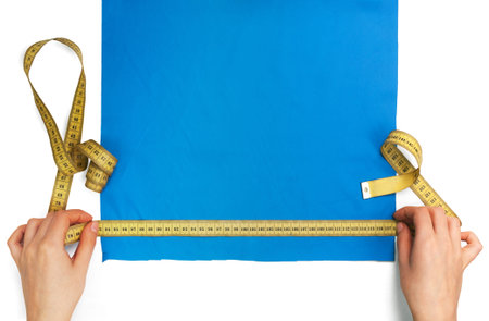 measures the size of a piece of blue cloth with a rulerの写真素材