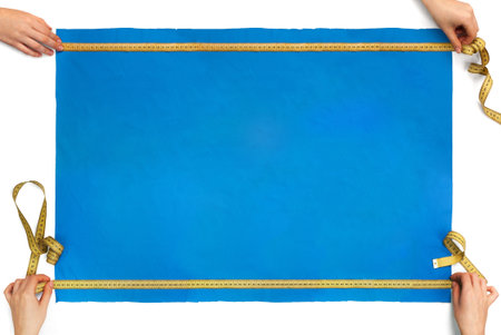 measures the size of a piece of blue cloth with a ruler