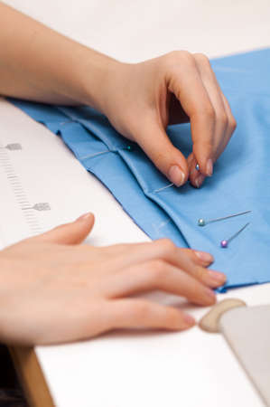 pushes a pin into the fabric on whiteの写真素材