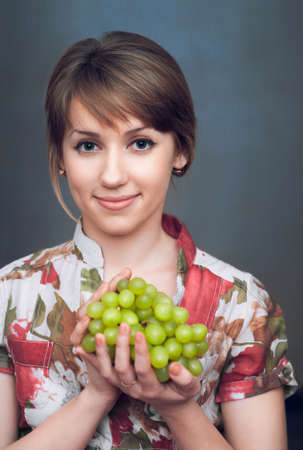 the nice girl is holding fresh grapesの写真素材