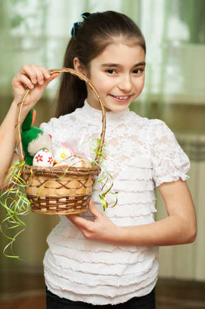 Beautiful teen girl with a basket of Easter eggsの写真素材