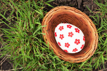 Easter Eggs in little basket on green grassの写真素材