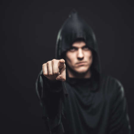 the guy in the black robe indicates youの写真素材