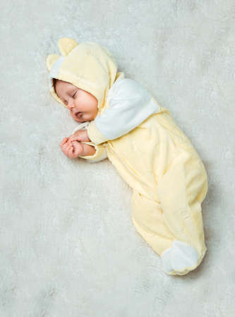 Little baby is sleeping on the white carpetの写真素材