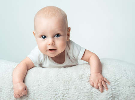 Little baby is smiling on the  white carpetの写真素材