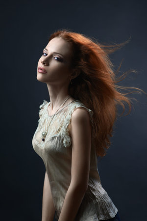 beautiful red-haired girl in the dark blue background