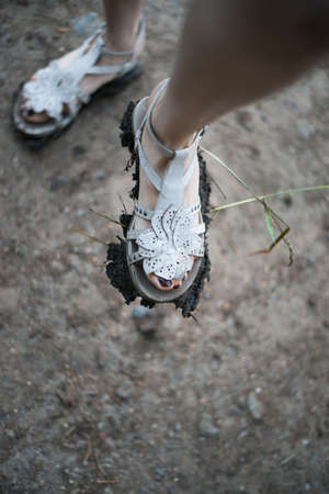 girl shows dirt on his sandalsの写真素材