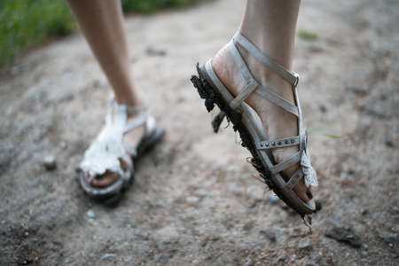 girl shows dirt on his sandalsの写真素材