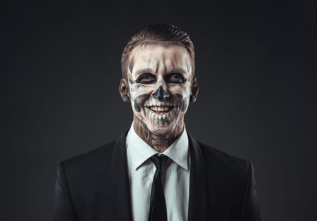 Portrait of laughing businessman with a make-up of the skeletonの写真素材