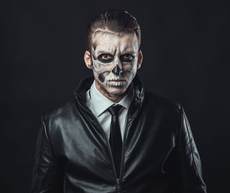 Portrait of pensive man with make-up of the skull