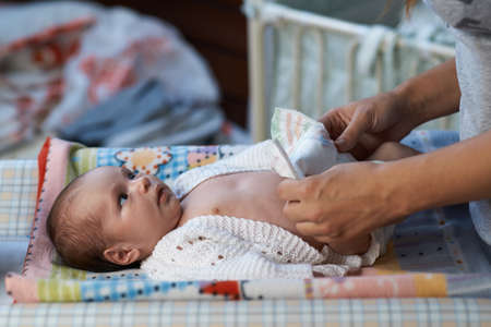 mom changing diapers newborn babyの写真素材